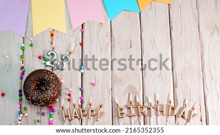 Birthday with number 23. Donut on the festive table. Happy birthday congratulations top view. Happy birthday card with beautiful decorations on a white board table.