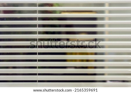 White office blinds cover the glass partition in the room. For use as a background.