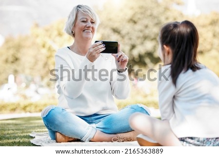 Grandma wants to capture as many memories with her. Shot of a grandmother taking photos of her granddaughter outdoors.