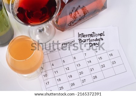 Top view glasses with alco drings and february calendar. International bartenders day.