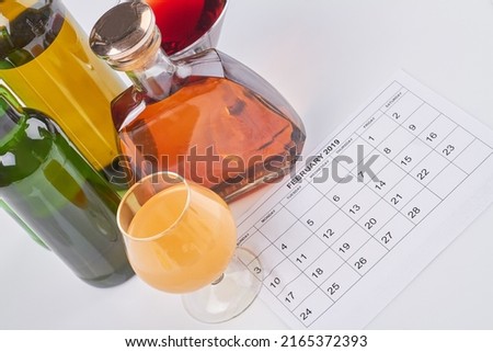 Set of various alcoholic drinks and calendar on white background. International bartenders day.