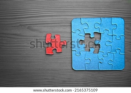 completing whole puzzle with last piece. photo for business design and infographic. jigsaw  with missing pieces in the center. Missing Jigsaw puzzle piece. wooden table surface. top view.