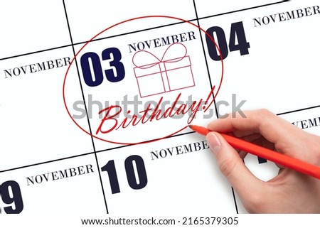 3rd day of November. The hand circles the date on the calendar 3 November, draws a gift box and writes the text Birthday. Holiday. Autumn month, day of the year concept.