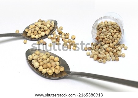a few spoonfuls of pepper and peppercorns that spilled out of the container. Royalty-Free Stock Photo #2165380913