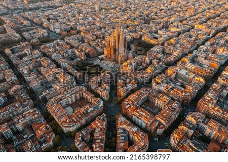 Aerial view of Barcelona Eixample residential district and Sagrada Familia Basilica at sunrise. Catalonia, Spain. Cityscape with typical urban octagon blocks Royalty-Free Stock Photo #2165398797