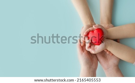 Happy Parents Day or International Day of Families. Happy mothers day. Mother and her childs holding Heart in the hands on blue background. Greeting card. copy space