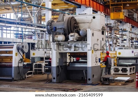 Technician operators working with with sheet metal on CNC hydraulic press brake. Royalty-Free Stock Photo #2165409599