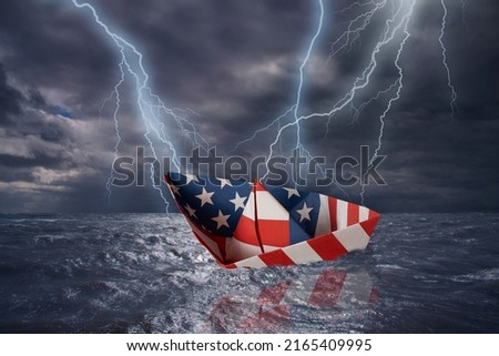 USA paper boat made as the flag of the US almost capsizes in high waves. Bolt of lightning in stormy dark sea weather during a thunder-storm with dramatic cloudscape. USA finacial crisis  concept.