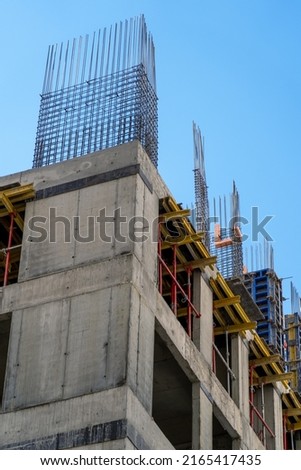 Steel reinforcement structure of rebars for concrete pouring at construction site. Housing construction, monolithic concrete frame of apartment block building under construction  Royalty-Free Stock Photo #2165417435