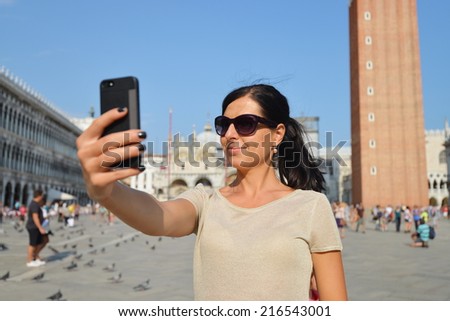 A beautiful young woman taking herself a selfie in Venice, Italy on Piazza San Marco