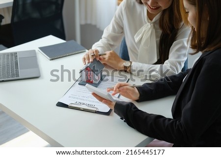 Guarantee, mortgage, contract, contract, signed, real estate agent or bank officer holding a calculator, submits a bid with a customer to buy a home before signing to make a deal