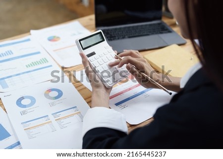 financial, Planning, Marketing and Accounting, Asian woman Economist using calculator to calculate investment documents with partners on profit taking to compete with other companies Royalty-Free Stock Photo #2165445237