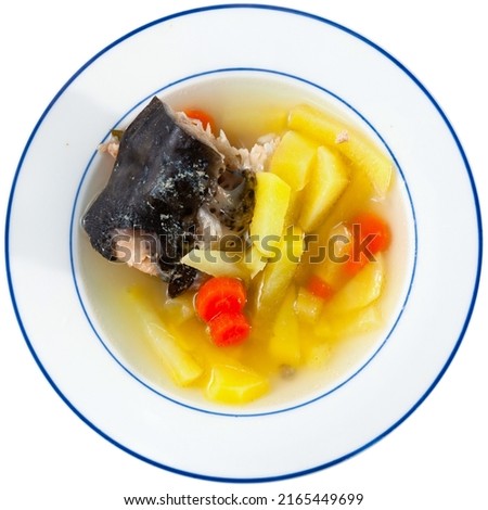 Thick fish soup with salmon head, potatoes and carrots slices served with crispy browned toasts. Isolated over white background.