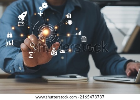 Businessman using a computer to AR virtual screen dashboard with project management with icons of scheduling, budgeting, communication.
