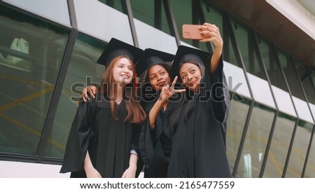 Group of friends having fun celebrating their graduation by taking pictures together.