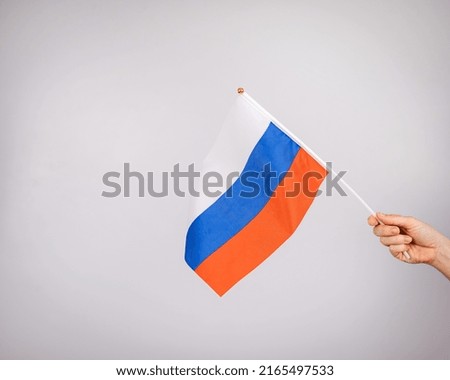 Woman holding a small flag of the Russian Federation on a white background. 
