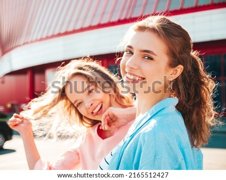 Two young beautiful smiling hipster female in trendy summer clothes.Sexy carefree women posing in the street. Positive pure models having fun at sunset, hugging and going crazy. Happy and cheerful Royalty-Free Stock Photo #2165512427
