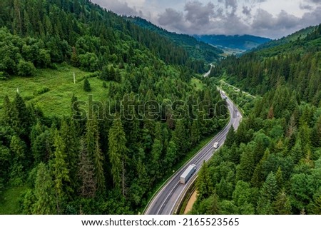 cargo truck on the higthway. cargo delivery driving on asphalt road through the mountains. seen from the air. Aerial view landscape. drone photography.  Royalty-Free Stock Photo #2165523565