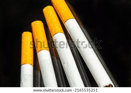some white and brown cigarettes, cigarettes allowed only for over eighteen, black background.