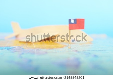 Selective focus of Taiwanese flag in blurry world map and wooden airplane model. Taiwan as travel and tourism destination concept.