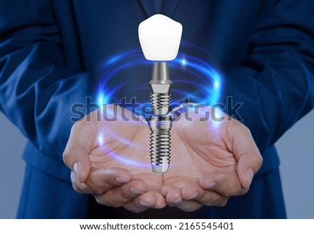Man demonstrating dental implant on light background, closeup