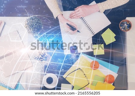 Multi exposure of hands making notes with world map hologram and data theme icons. Concept of global computer data.