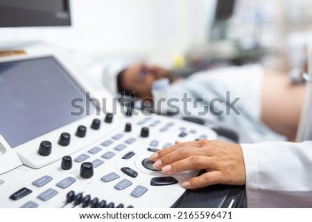 Young male patient lying on bed and having ultrasound examination of abdomen in medical clinic Royalty-Free Stock Photo #2165596471