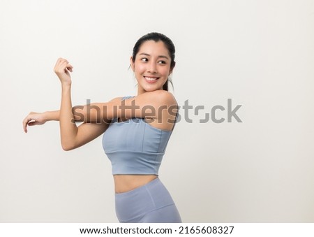 Young beautiful asian woman with sportswear stretching arms warming up on isolated white background. Portrait sporty woman standing pose exercise workout in studio. Royalty-Free Stock Photo #2165608327