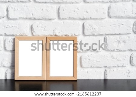 Photo frame with copy space against white brick wall, close up