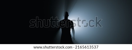 Silhouette of a man in the rays of spotlight.