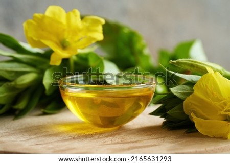 A bowl of evening primrose oil with fresh blooming Oenothera biennis plant  Royalty-Free Stock Photo #2165631293