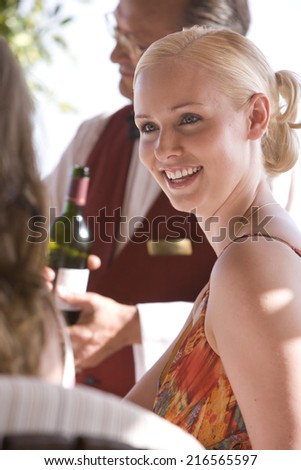 Close up of smiling woman with waiter in background