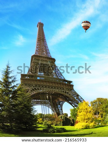 Hugel Eiffel Tower. At the foot of the tower is designed park with paths and pond. In the sky next to the tower floats giant balloon. The picture was taken Fisheye lens