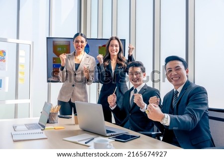 A group of young businessmen in suits, Asians, are determined and excited about their work. and encourage the team members by raising their hands happily Royalty-Free Stock Photo #2165674927