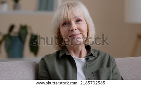 Web cam view close up happy friendly older 60s woman looking at camera talking distant remote conference calling video chat at home. Smiling senior mature adult lady grandmother speak to webcam online Royalty-Free Stock Photo #2165702565