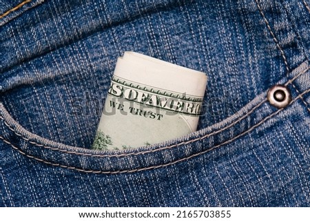 Dollars in the pocket of blue denim pants close up