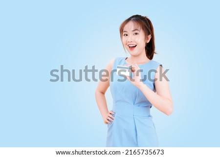 Portrait of Asian young beautiful and cheerful woman using credit card to pay online, isolated on background