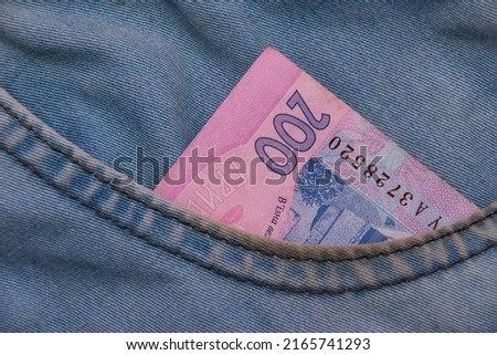 Ukrainian hryvnia money in the pocket of denim pants. The concept of financial assistance to Ukrainians.