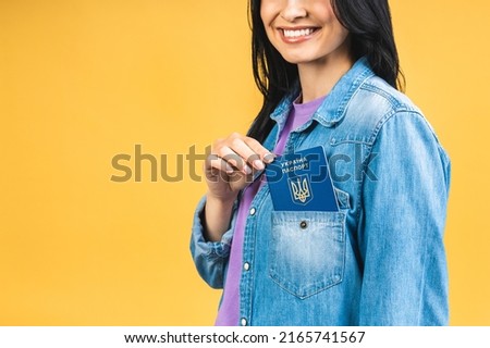 Portrait of nice beautiful lovely glad cheerful woman holding in hands ukrainian passport, having fun isolated over yellow pastel color background.