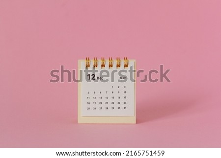 Desktop calendar for December 2022 on a pink background. Royalty-Free Stock Photo #2165751459
