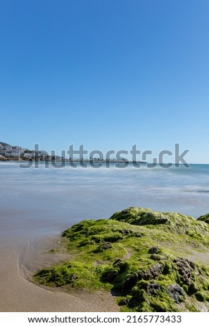 Long exposure photography the morning. Sitges' beach. Detail of rocks