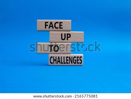Face up to challenges symbol. Wooden blocks with words Face up to challenges. Beautiful blue background. Business and Face up to challenges concept. Copy space
