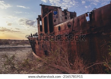 Old ships on the former bank of Aral sea during sunrise, Muynak, Uzbekistan Royalty-Free Stock Photo #2165781911