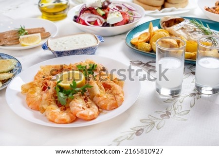 Grilled prawns or shrimps with lemon, top view. Traditional Greek tavern menu. Variety of seafood dinner.  Royalty-Free Stock Photo #2165810927