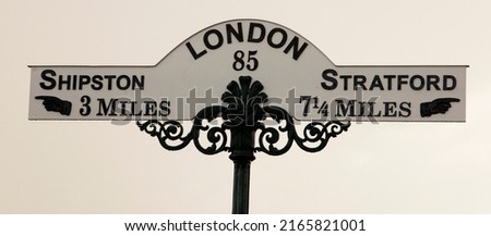 A ornate vintage road sign showing London 85 miles away, Stratford (on Avon) 7.25 miles in one direction and Shipston 3 miles in the other.