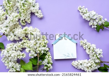 Spring summer background. white lilac an, figure of a house on a lilac background. Color of the year 2022.
