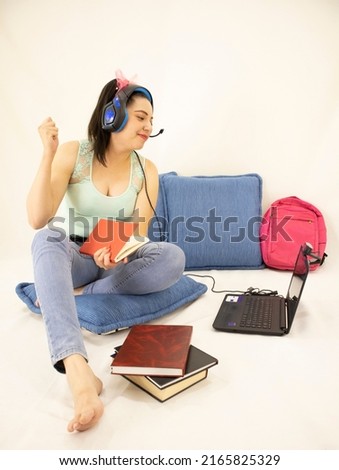 happy young student woman studying with headphones, books, web camera, computer and backpack