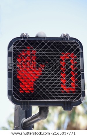 Pedestrian crosswalk traffic signal with red stop hand and zero