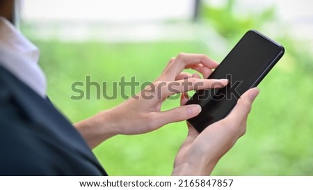 Close-up and focus hands image, A female using modern smart mobile phone, touching on screen, scrolling on social media.