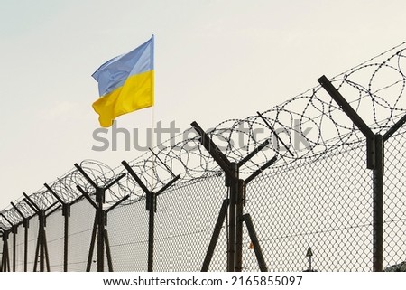 Concept of Ukraine closed borders with flag and wire fence. Ukraine immigration and homeland security. Ukrainian Russian border Royalty-Free Stock Photo #2165855097
